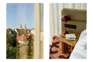 克拉科夫克拉科夫PURO斯塔勒米亚斯托酒店的一间带椅子和一张桌子及窗户的房间