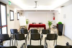 维贡扎Matrix Hotel & Residence的一间设有椅子和一张红色桌子的房间