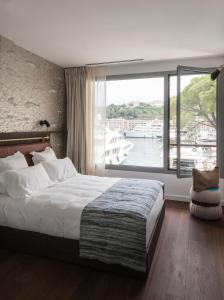 蒙特卡罗Boutique Hotel Miramar的一间卧室设有一张大床和一个大窗户