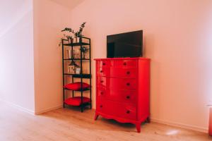 NašiceX Rooms的红色梳妆台,上面有电视