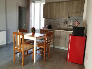 拉古萨Locazione turistica da Enzo e Maria的厨房配有桌椅和红色冰箱。
