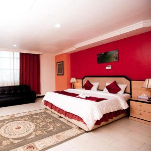 达累斯萨拉姆梅费尔酒店的一间卧室设有一张大床和红色的墙壁