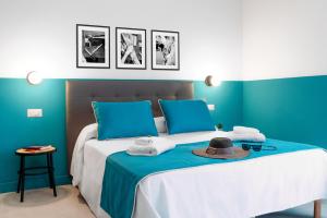 索伦托Sorrento Colors&Suites的一张带蓝色墙壁和帽子的床