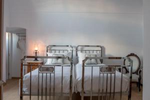 费拉Casasantantonio 18th Century Luxury Mansion的一间卧室配有两张带白色床单的床