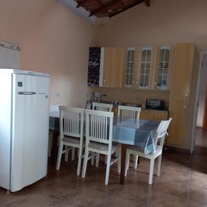 贡萨尔维斯Recanto Flor de lis的厨房配有桌椅和冰箱。
