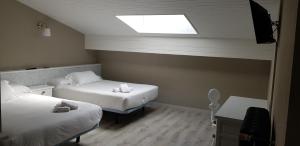NavecesHotel Marqués de la Moral的小房间设有两张床和天窗