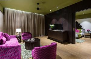乌代浦拉肯德酒店的客厅配有紫色家具和1张床