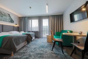 维斯瓦波德杰德拉米酒店的酒店客房带两张床和一张桌子以及椅子。