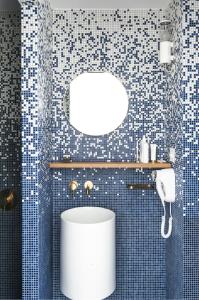 蒙特卡罗Boutique Hotel Miramar的浴室设有蓝色瓷砖墙壁,配有白色卫生间
