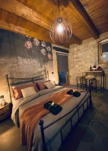 CastelmauroB&B Il Fabbro Chambre的卧室配有一张石墙内的大床