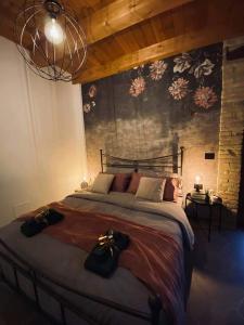 CastelmauroB&B Il Fabbro Chambre的一间卧室设有一张大床和鲜花墙