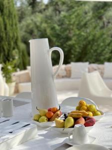 奥斯图尼Pietrefitte的白花瓶和桌子上的一盘水果
