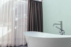 圣莱奥纳尔多因帕西里亚蒂罗列奥佛酒店的带窗户的浴室内的白色浴缸