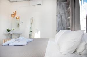 帕罗奇亚Crystal Dreams的白色卧室,床上配有白色枕头