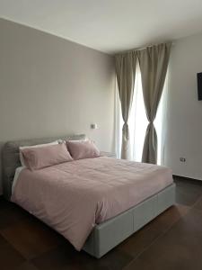 巴里Relais Petruzzelli的一间卧室配有带粉红色枕头的床和窗户。