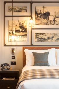 卡迪夫加的夫靛蓝酒店的卧室配有一张墙上挂有照片的床