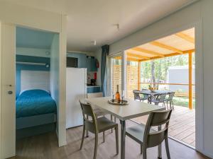 乌马格Adriamar Mobile Homes in Camping Park Umag的厨房以及带桌椅的用餐室。