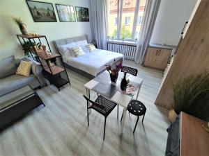 比亚韦斯托克Apartamenty Rynek的客厅配有床和桌子