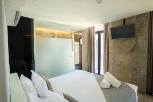 加亚新城CHARM by YoursPorto的卧室配有白色的床和墙上的电视