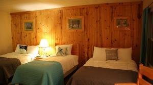 马尼斯蒂克Holiday Motel的木墙客房的两张床