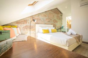 加亚新城CHARM by YoursPorto的一间卧室设有一张大床和石墙