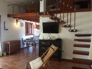 GuarazocaCasa La Casamera的一间配有平面电视的客厅和楼梯