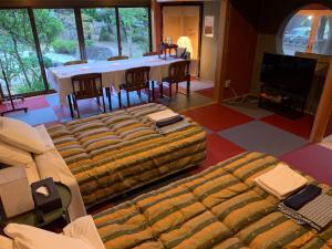 Kasaokaオーベルジュ美の浜 流石的客厅配有桌椅和沙发