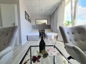 比亚韦斯托克Apartamenty Rynek的一间设有两张床的客房,玻璃桌上放有一瓶葡萄酒