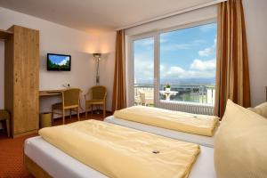 伦茨基希JUFA Hotel Schwarzwald的酒店客房设有两张床和窗户。