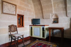 于尔居普古尔科纳克拉兹辛那索斯特类酒店 的配有电视、椅子和桌子的房间
