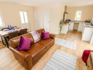 滕比Caldey Lodge Bier Wood Lodges的客厅配有棕色沙发和紫色枕头