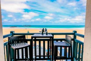 圣马洛查莫特斯酒店的俯瞰海滩的阳台配有一张桌子和两把椅子