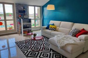 安杰利圣母L'attico delle Meraviglie - SUITE BellaVista的客厅配有白色沙发和蓝色的墙壁