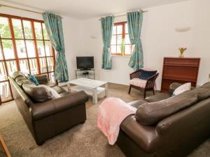格文Brunston Castle的客厅配有两张真皮沙发和一台电视机
