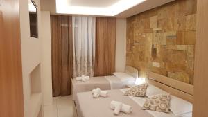 福洛尼卡Affittacamere Casa Brajan的酒店客房设有两张床和石墙。