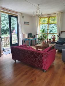 EwijkBlauwe Lelie的客厅配有红色的沙发和桌子