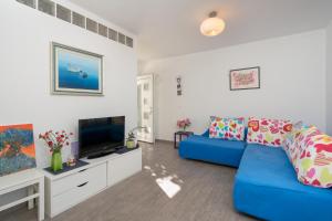 杜布罗夫尼克Teranino Apartment的客厅配有蓝色的沙发和电视
