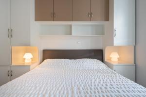 杜布罗夫尼克Teranino Apartment的卧室配有带两盏灯的白色床