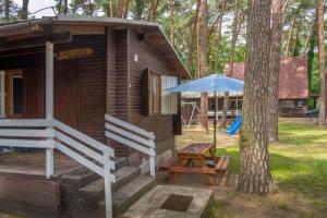 博茨科沃Ow Oliwia的小木屋配有野餐桌和雨伞