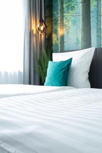 萨尔堡Gästehaus&Pension Pinske的一张带白色床单和蓝色枕头的床