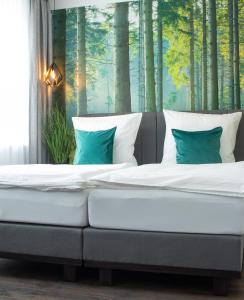 萨尔堡Gästehaus&Pension Pinske的卧室里的一张床位,卧室里种植了树木壁画