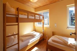 贝曹Sonne Bezau - Familotel Bregenzerwald的黄色墙壁的客房内设有两张双层床。