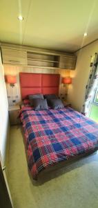 格兰奇奥沃桑茨The Hideaway的一间卧室配有一张红色床头板的床