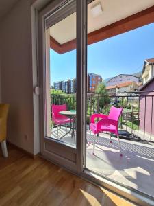 索科矿泉村Apartman Jelena Sokobanja的客房设有带粉红色椅子和桌子的阳台。