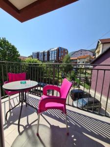索科矿泉村Apartman Jelena Sokobanja的阳台配有2把粉红色的椅子和1张桌子