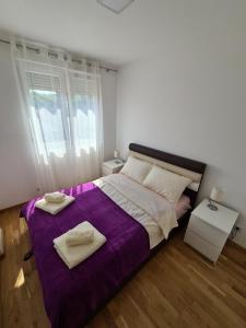 索科矿泉村Apartman Jelena Sokobanja的一间卧室配有一张紫色床和两条毛巾