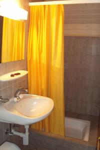 博内夫斯库罗纳餐厅酒店的浴室设有水槽和黄色的淋浴帘
