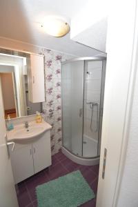 希贝尼克Apartmani Mihaela的一间带水槽和玻璃淋浴的浴室