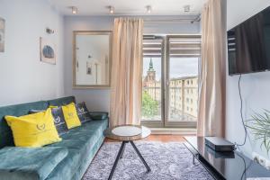 格但斯克Apartamenty Gdansk EU - Waterlane - Apartament Marina - Old Town的客厅设有绿色沙发和窗户。