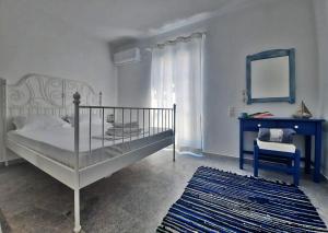 纳克索乔拉BLUE IN NAXOS的一间卧室配有一张床、镜子和椅子